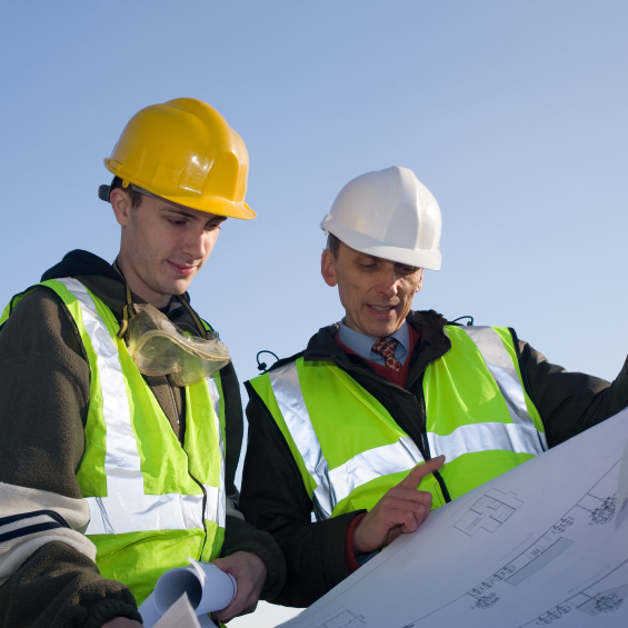 Workers in hard hats examining blueprints